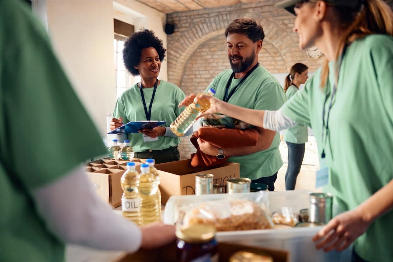 Voluntários em camisetas verdes organizando doações de alimentos