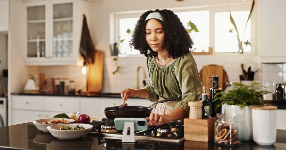 Nutri+ Mulher cozinhando usando o serviço Nutri+ da TotalPass.