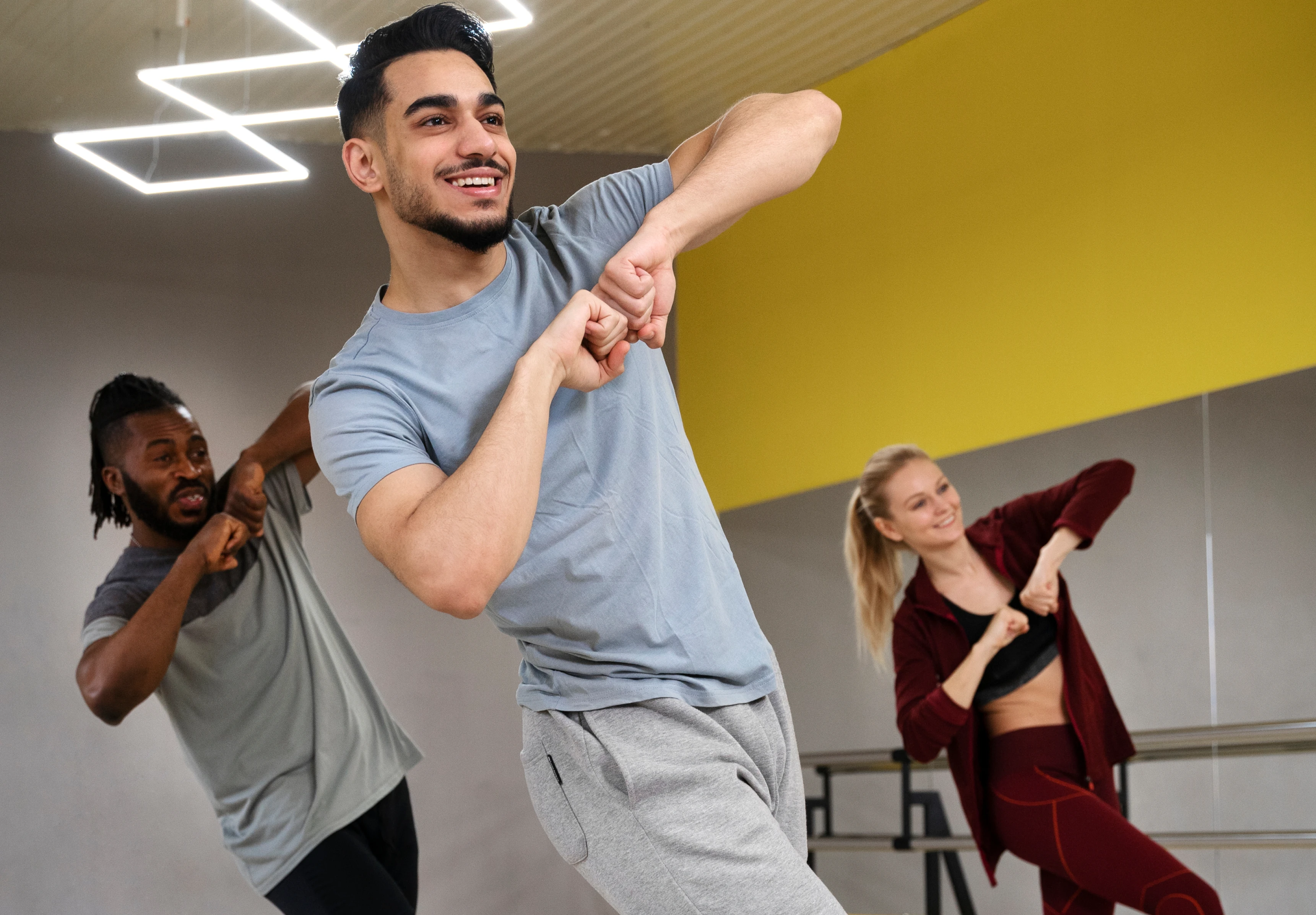 Dos hombres y una mujer en el salón de un estudio, tomando clases de baile y aprovechando que con TotalPass tienen más de 250 actividades para probar.