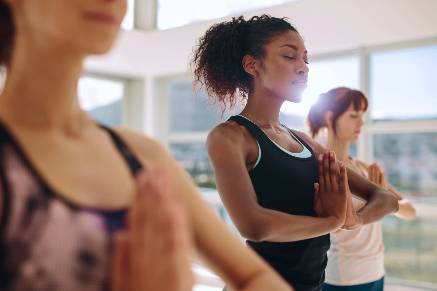 A imagem tem três mulheres meditando.