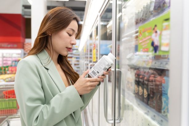 mulher escolhendo leite no mercado