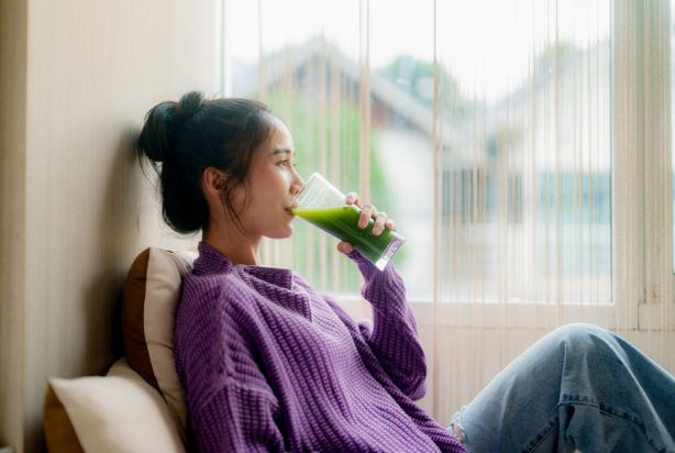 mulher tomando suco verde