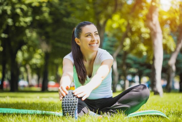 mulher se alongando feliz no parque