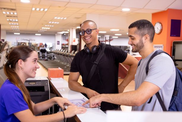 homens na recepção da academia fechando plano