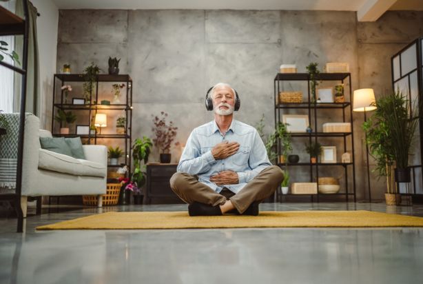 senhor praticando meditação guiada em casa