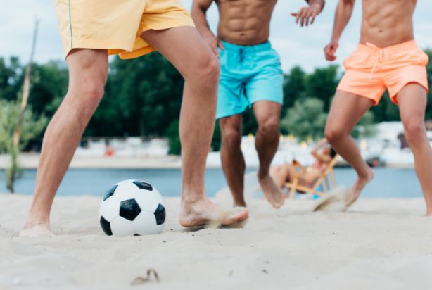 pessoas jogando futebol de areia