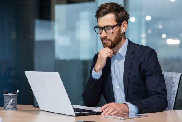 homem sério analisando dados no trabalho