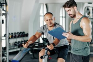 homem cumprindo sua ficha de treino com personal