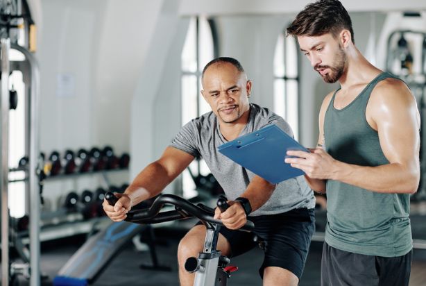 homem cumprindo sua ficha de treino com personal