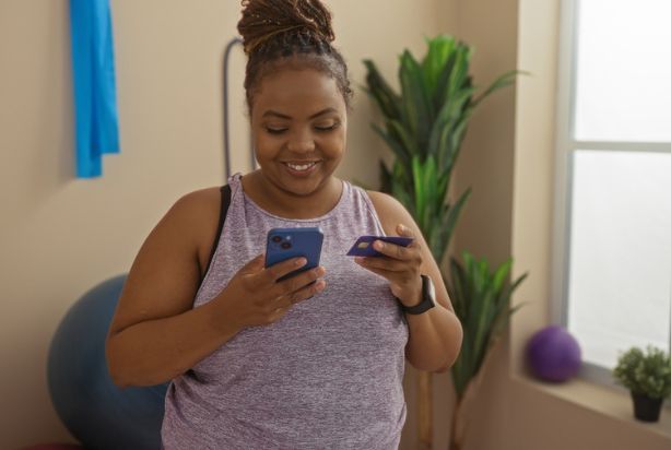 mulher no celular com cartão de crédito
