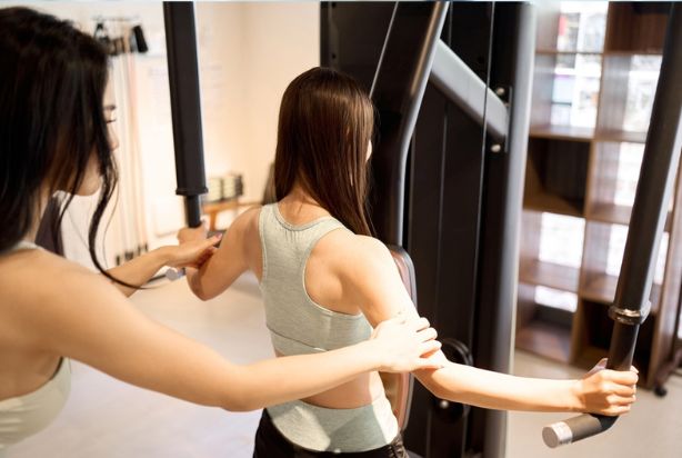 mulher na academia fazendo crucifixo inverso