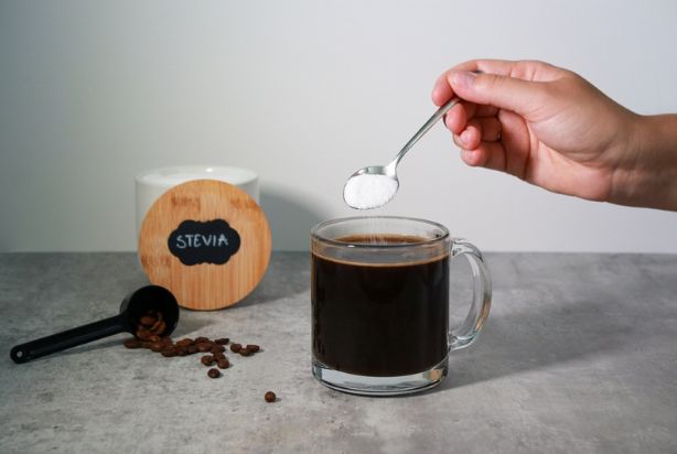 pessoa colocando stevia no café