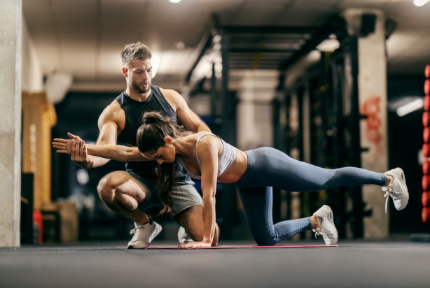 Mulher fazendo exercício perdigueiro com ajuda profissional