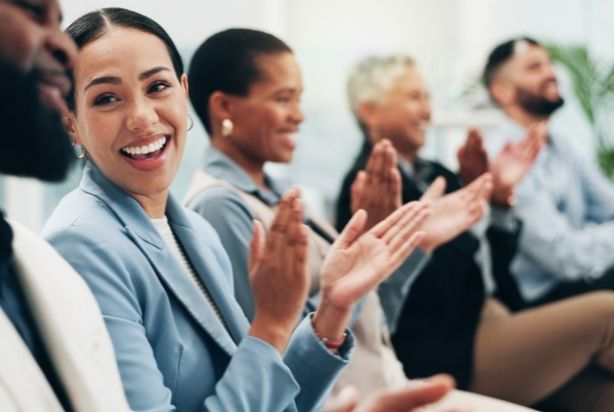 Mulher batendo palmas em ambiente corporativo