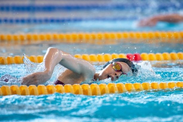 Mulher nadando em piscina olímpica