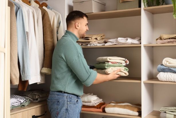 Homem organizando guarda roupas