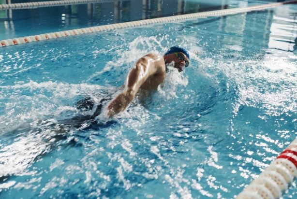 Homem nadando sozinho na piscina