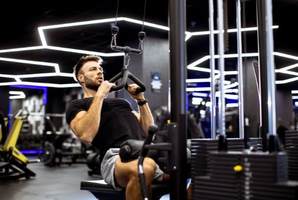 Homem praticando exercício físico na academia.